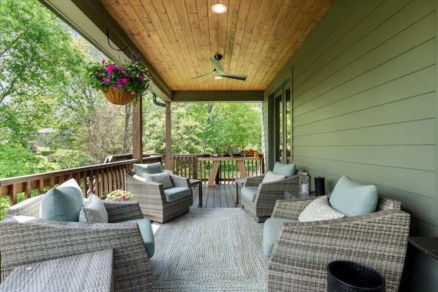 wooden terrace featuring ceiling fan and an outdoor living space