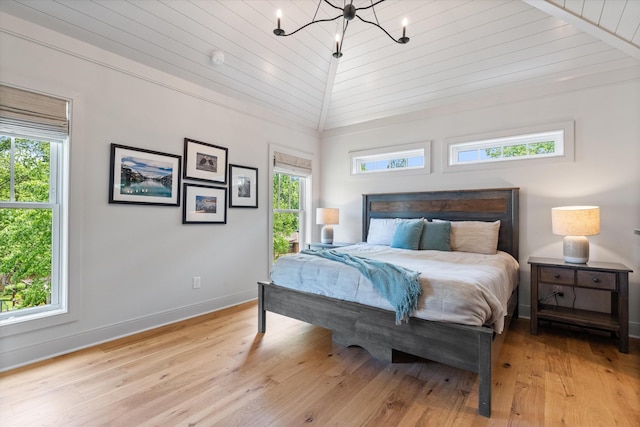 bedroom featuring baseboards, a notable chandelier, and light wood-type flooring