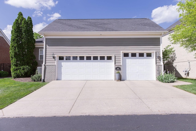 view of front facade with an attached garage, driveway, and a shingled roof