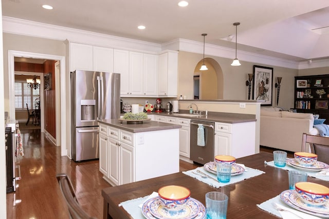 kitchen with white cabinets, dark wood-style flooring, dark countertops, stainless steel appliances, and open floor plan