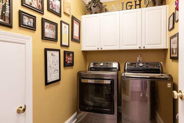 washroom featuring separate washer and dryer, baseboards, and cabinet space