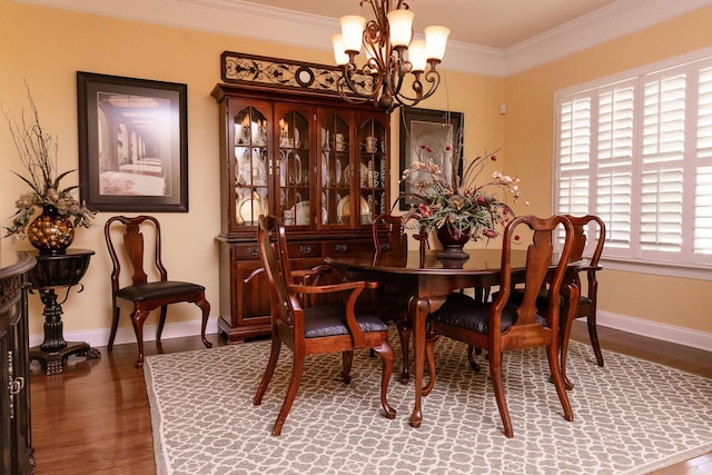 dining area featuring crown molding, an inviting chandelier, baseboards, a healthy amount of sunlight, and wood finished floors