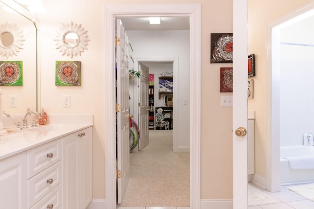 full bath with vanity, baseboards, and a tub