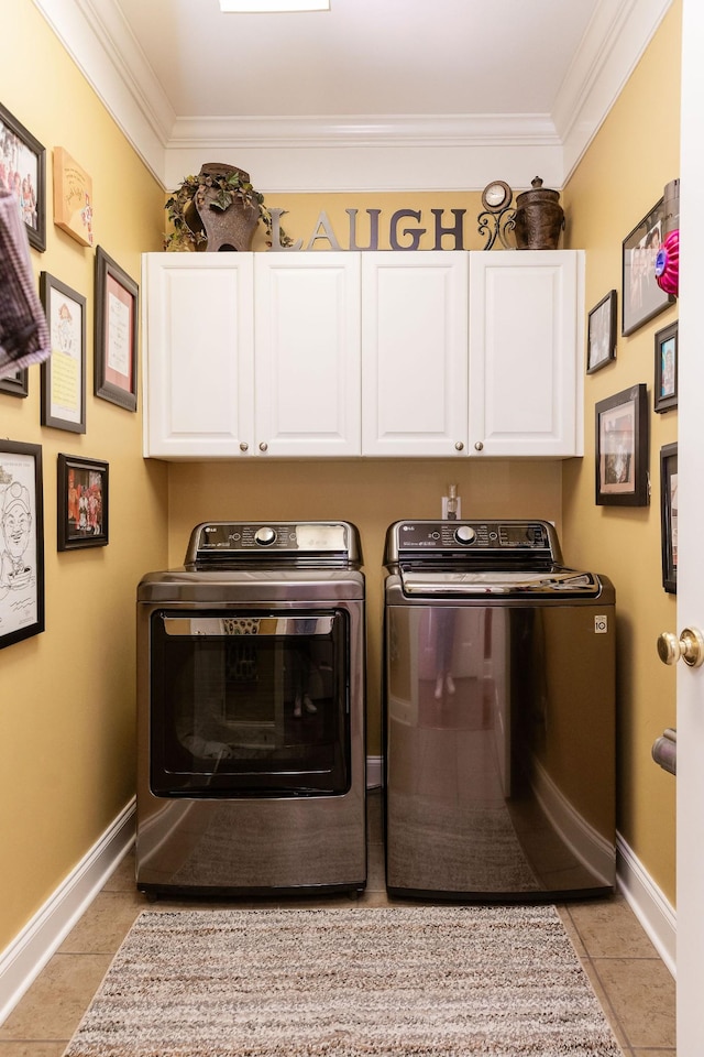 clothes washing area with cabinet space, washing machine and clothes dryer, baseboards, light tile patterned floors, and ornamental molding