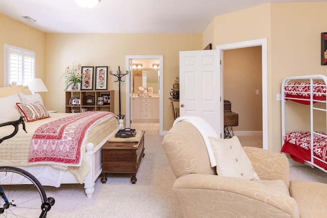 carpeted bedroom with visible vents and ensuite bathroom