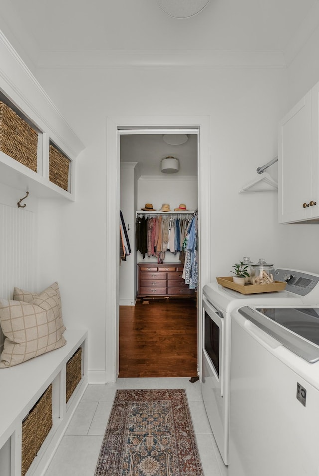 449 River Bluff Dr, Franklin, TN 37064 - washroom featuring light tile patterned floors, separate washer and dryer, ornamental molding, and cabinet space