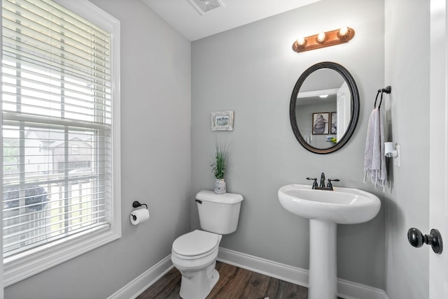 bathroom featuring visible vents, baseboards, wood finished floors, and a healthy amount of sunlight