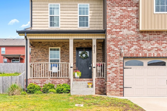 entrance to property featuring brick siding, a garage, fence, and covered porch