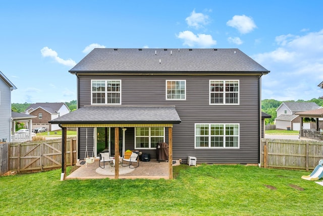 rear view of house featuring a fenced backyard, a lawn, and a patio area