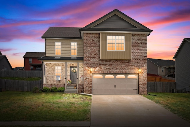 traditional home with fence, brick siding, a garage, a lawn, and driveway