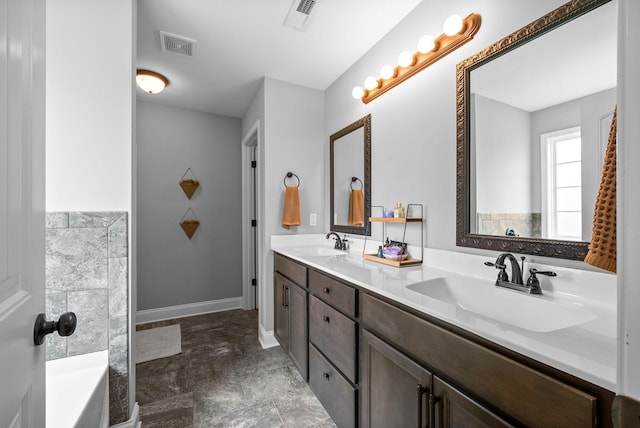 bathroom featuring double vanity, visible vents, and a sink