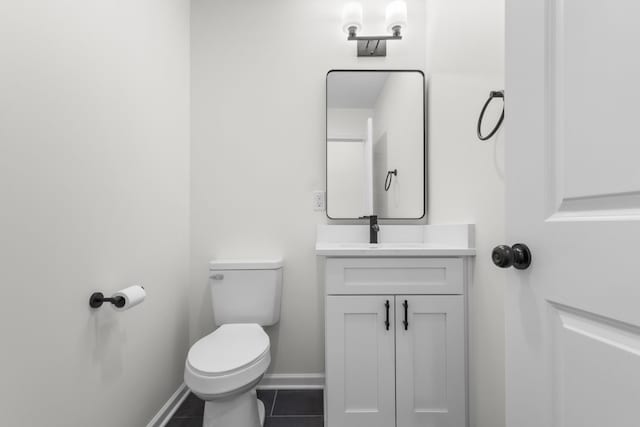 bathroom with baseboards, tile patterned floors, vanity, and toilet