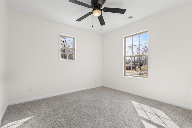 spare room featuring a ceiling fan, baseboards, visible vents, and carpet