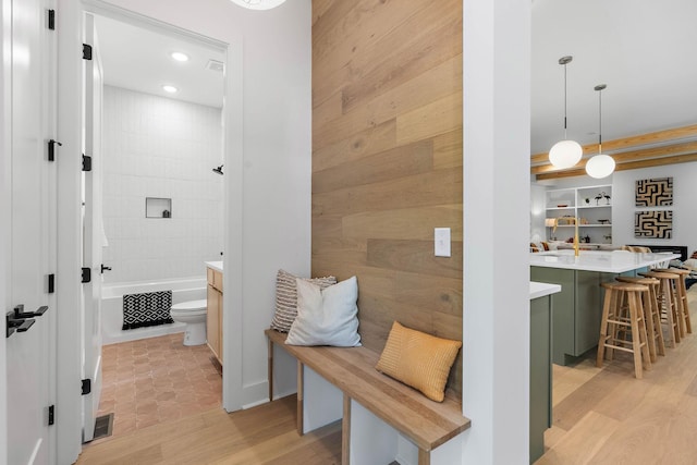 mudroom featuring wooden walls, recessed lighting, visible vents, and light wood finished floors