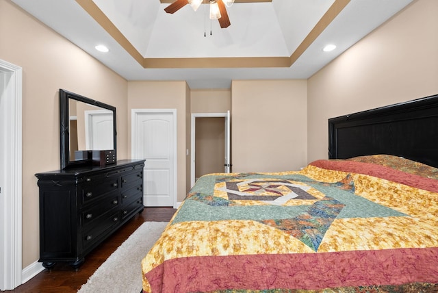 bedroom featuring ceiling fan, a raised ceiling, recessed lighting, baseboards, and dark wood-style floors