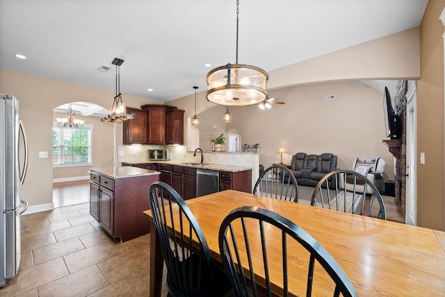 dining space featuring arched walkways, ceiling fan with notable chandelier, recessed lighting, baseboards, and a toaster