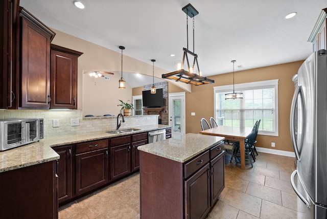 kitchen with decorative light fixtures, appliances with stainless steel finishes, tasteful backsplash, a sink, and a toaster