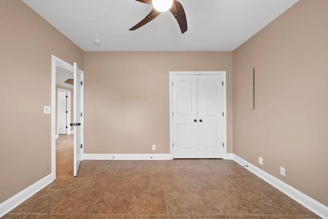 unfurnished bedroom with a closet, a ceiling fan, and baseboards