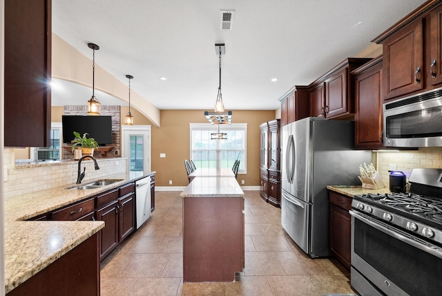 kitchen featuring a sink, a kitchen island, backsplash, and stainless steel appliances
