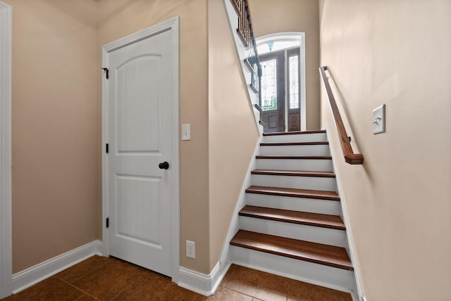 staircase featuring baseboards and tile patterned flooring