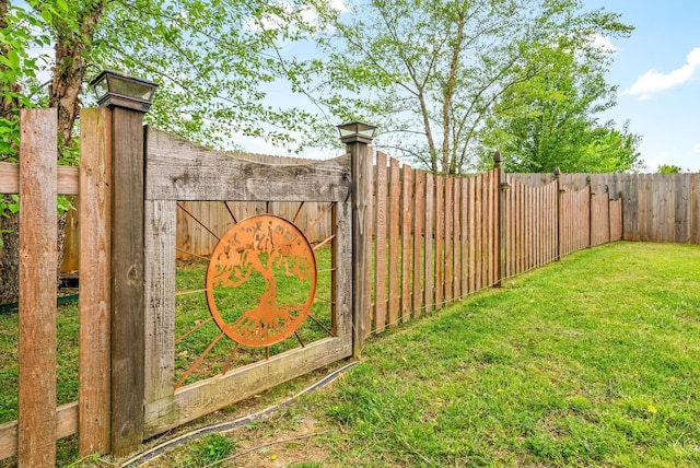 view of gate featuring fence and a yard
