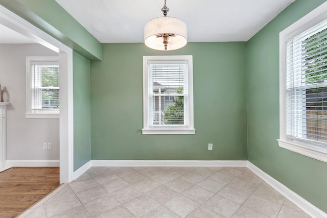 unfurnished room featuring baseboards and light tile patterned floors