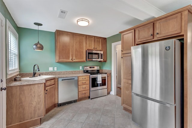 kitchen featuring visible vents, pendant lighting, light countertops, a sink, and stainless steel appliances