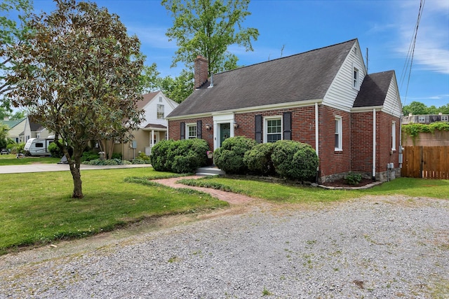cape cod house featuring brick siding, fence, a chimney, and a front lawn