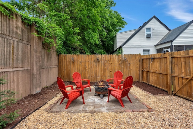 view of patio / terrace featuring a fenced backyard, a gate, and a fire pit