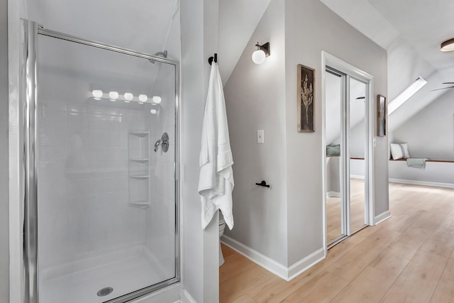 full bath featuring baseboards, wood finished floors, and a shower stall