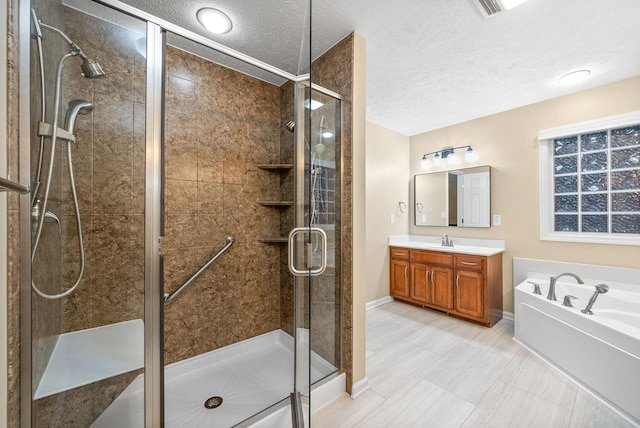 bathroom with vanity, a bath, a textured ceiling, and a stall shower