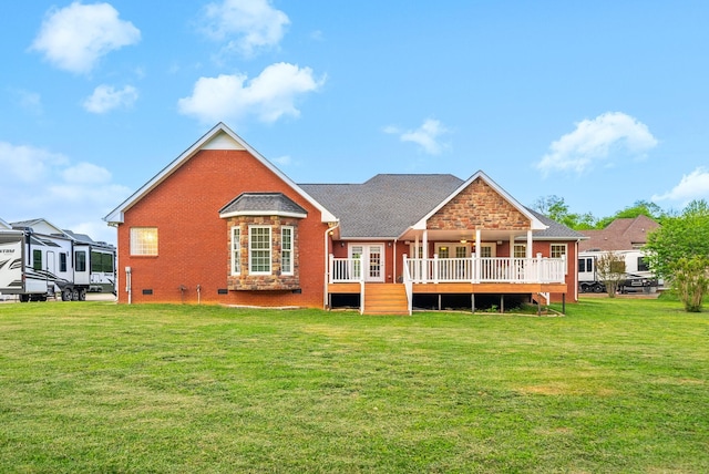 back of house featuring a lawn, brick siding, and a deck
