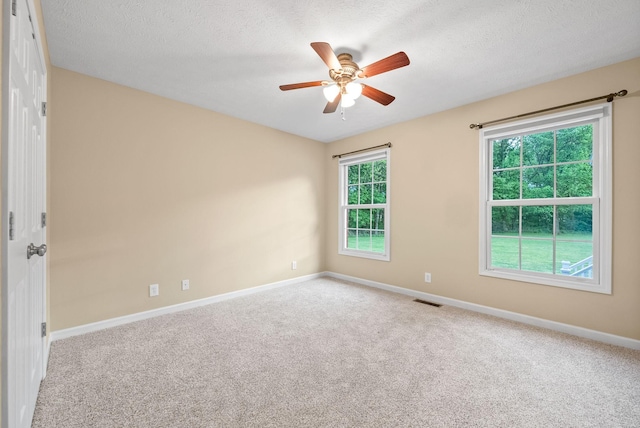 empty room featuring baseboards, visible vents, ceiling fan, and carpet