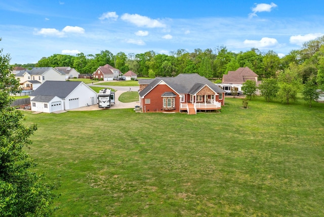 back of property featuring a lawn, a wooden deck, driveway, and a residential view