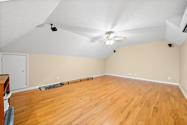bonus room with a ceiling fan, baseboards, light wood-style flooring, and lofted ceiling