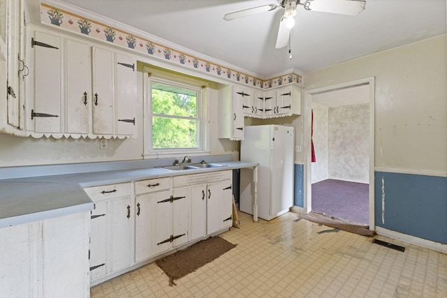 kitchen featuring freestanding refrigerator, light floors, ceiling fan, light countertops, and a sink