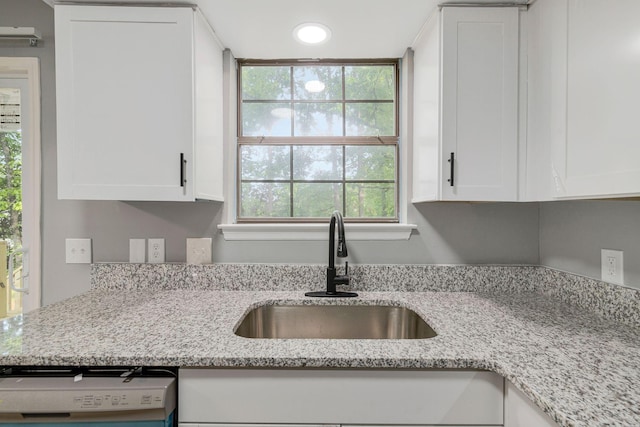 kitchen with white cabinetry, a healthy amount of sunlight, a sink, and dishwashing machine