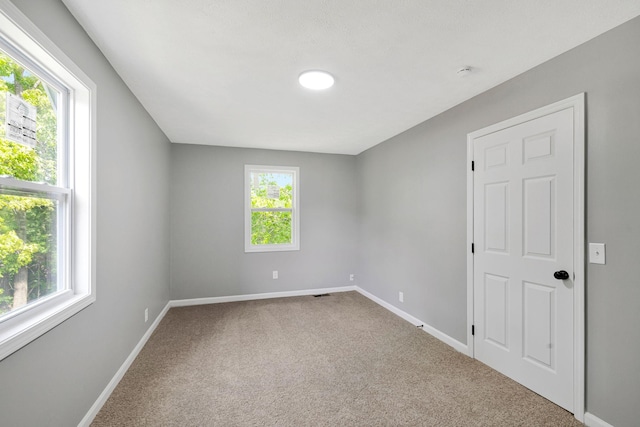 spare room featuring baseboards and carpet floors