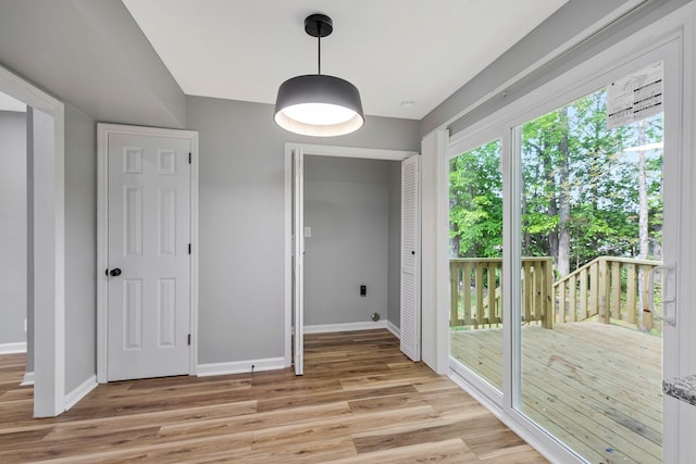 unfurnished dining area featuring light wood-style floors and baseboards