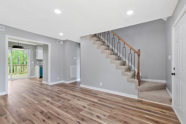 entryway with baseboards, wood finished floors, and stairway