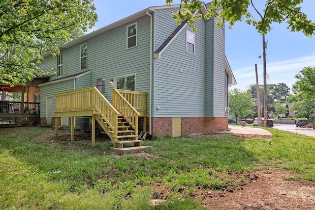 back of house featuring a wooden deck, a yard, and stairway