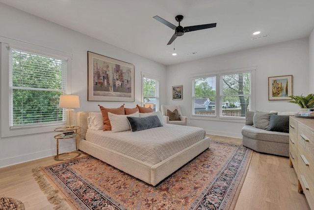 bedroom featuring visible vents, a ceiling fan, baseboards, and light wood-type flooring