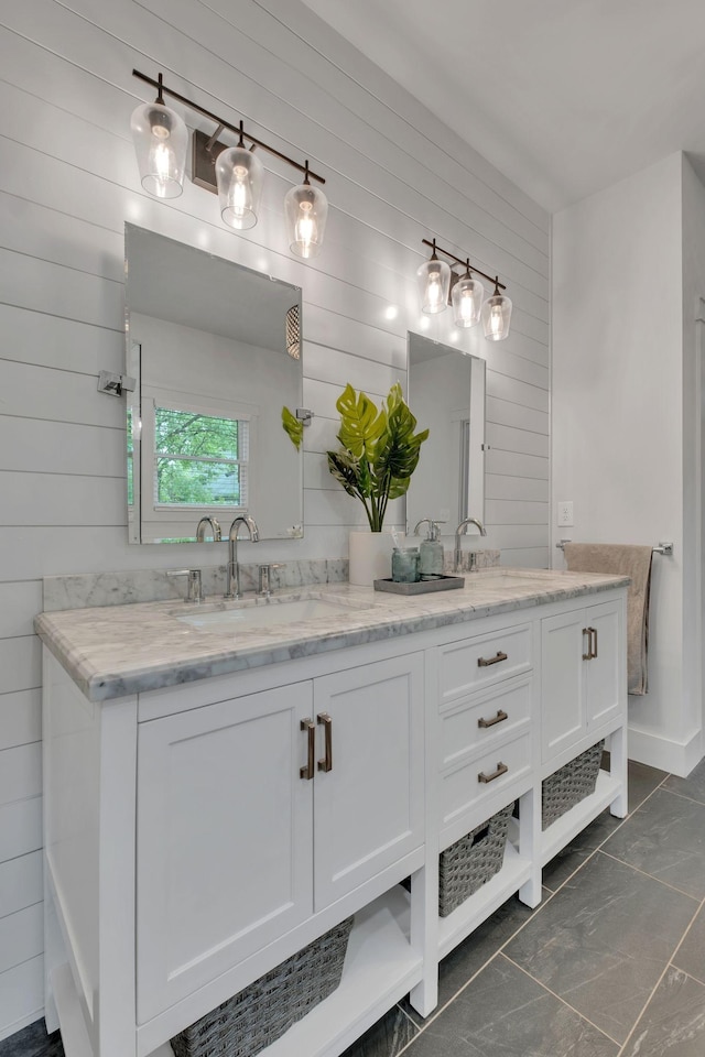 bathroom with double vanity, wood walls, and a sink