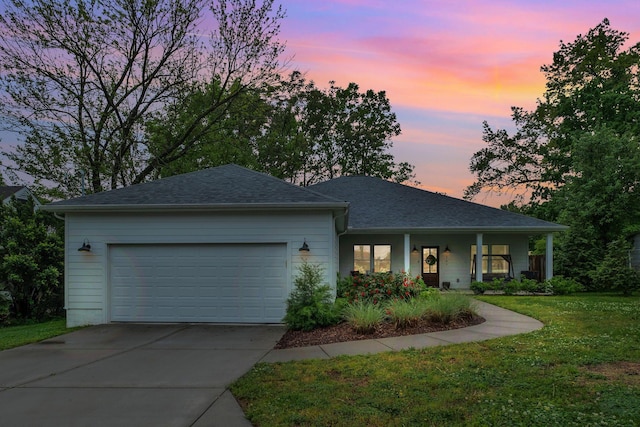 single story home featuring roof with shingles, an attached garage, concrete driveway, and a front lawn