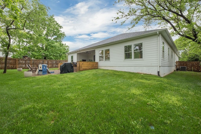 back of property with a yard, cooling unit, and a fenced backyard