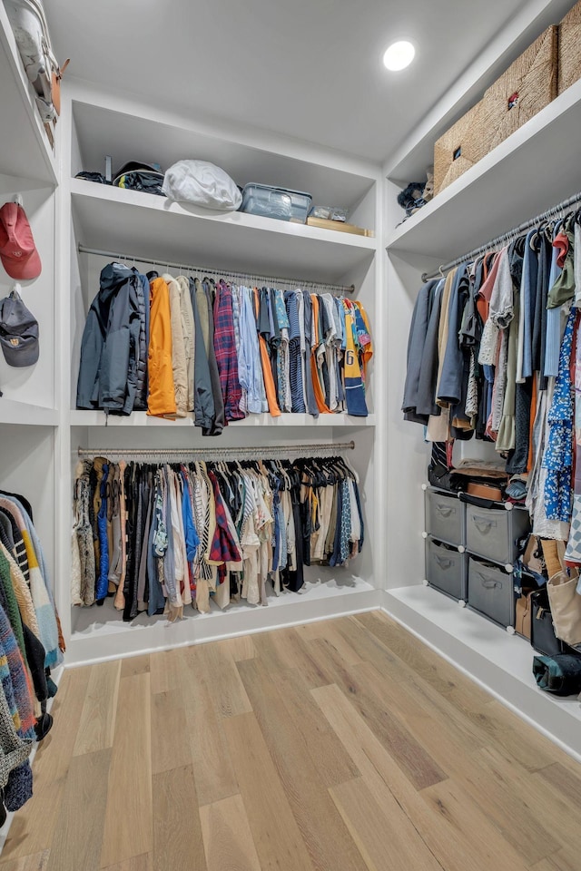 walk in closet with wood finished floors