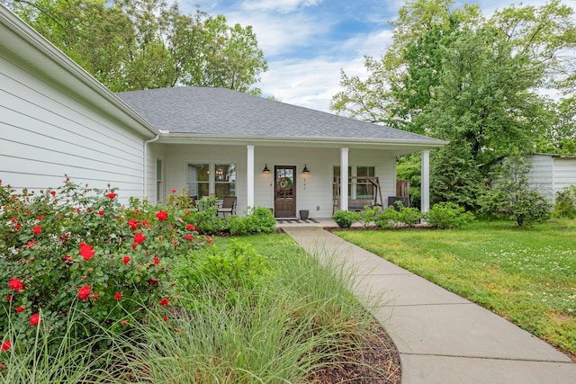 view of front of house featuring a porch, a shingled roof, and a front lawn