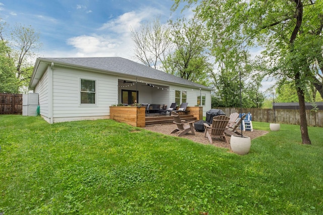 rear view of house with a lawn, a ceiling fan, a fenced backyard, and a patio