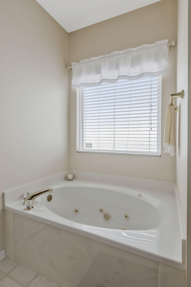 bathroom with tile patterned floors, a tub with jets, and plenty of natural light