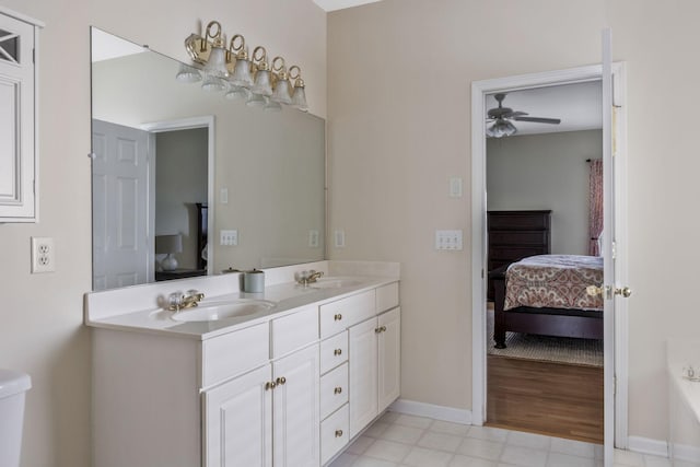 ensuite bathroom with a sink, a ceiling fan, double vanity, and connected bathroom